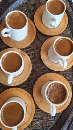 four cups of coffee are arranged in a circle