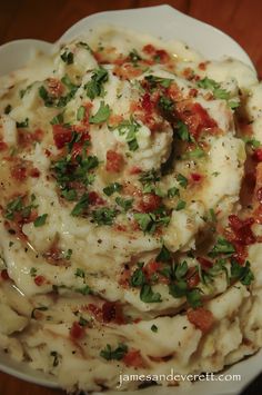 a white plate topped with mashed potatoes covered in sauce and garnished with parsley