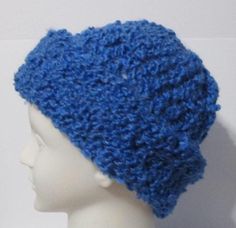 a white mannequin head wearing a blue crocheted hat on top of it