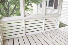 an empty porch with white paint and wood flooring