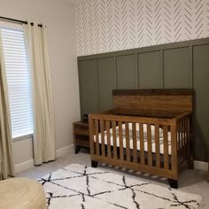 a baby's crib in the corner of a room with a rug on the floor