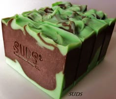 a close up of a soap on a white surface with green and brown swirls