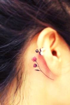 a close up of a person's ear with flowers on it