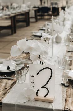 the table is set with white flowers and place cards