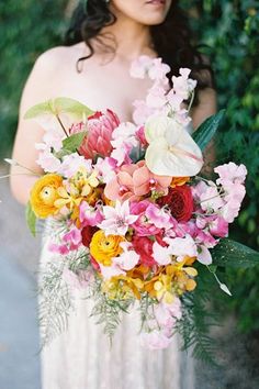 a woman holding a bouquet of flowers in her hands