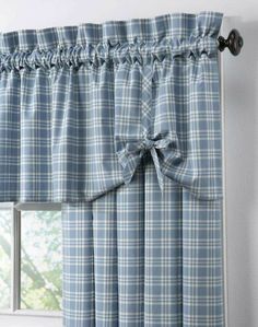 a blue and white checkered window curtain with a bow tie on the valil