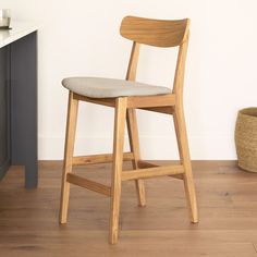 a wooden chair sitting on top of a hard wood floor next to a white wall