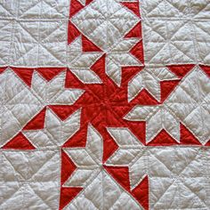 a red and white quilt with many small stars on the top, along with two rows of smaller ones