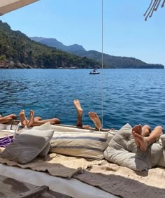 two people laying on the back of a boat with their feet up in the air