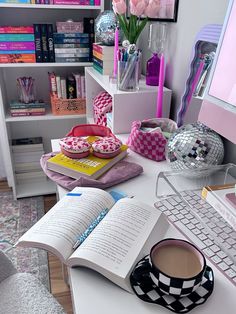 a desk with a book, cup of coffee and a laptop on top of it