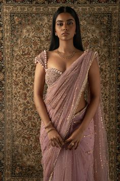 This dusty pink sari is a vision of elegance, crafted from net fabric that glimmers with every movement. Paired with a net blouse, the ensemble radiates sophistication and charm. The intricately hand-embroidered blouse adds a touch of glamour, making it perfect for a cocktail or reception, whether for the bride or her bridesmaids. With its timeless allure and delicate detailing, this sari is sure to captivate attention and leave a lasting impression on any special occasion. Celebrity Lehenga Outfits, Pink Saree With Pink Blouse, Dusky Pink Saree, Cocktail Saree Blouse, Blouse Designs On Silk Saree, Blouse For Wedding For Women, Cocktail Blouse Designs, Pretty Sarees Beautiful, Net Saree For Farewell