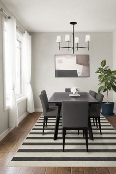 a dining room table with chairs and a potted plant in the middle of it