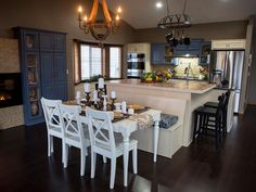 a dining room table and chairs in front of an island with built - in fireplace