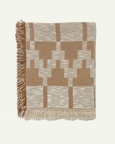 a brown and white blanket with fringes on it