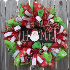 a christmas wreath with santa clause on it and the word home is hanging on a fence