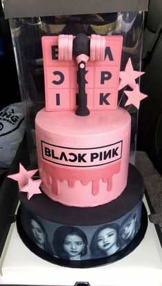 a pink and black cake sitting on top of a table