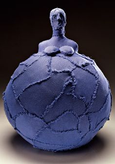 a blue ball with a woman sitting on it's side and the top half torn off