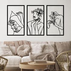 three black and white paintings on the wall above a couch