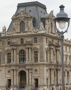 people are walking around in front of an old building