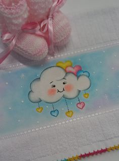 a teddy bear sitting on top of a table next to a card with a cloud