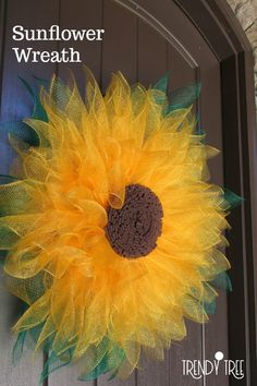 a yellow and green sunflower is hanging on the front door