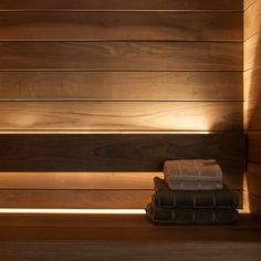 towels are sitting on the edge of a saunage with wood paneling behind it