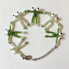 a bracelet made out of beads and charms on a white surface with a silver chain