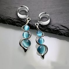 a pair of earrings with blue stones hanging from them