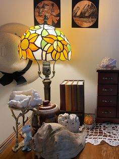 a lamp sitting on top of a wooden table next to a book and other items