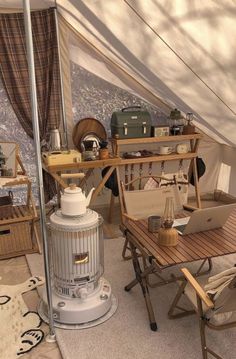 the interior of a tent with various items on it, including a table and chairs