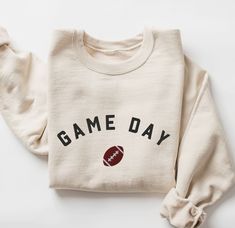 a white sweatshirt with the words game day on it and a football drawn in black