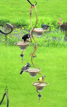 a wind chime with birds on it in the grass