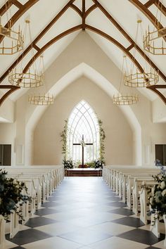 an empty church filled with white chairs and flowers