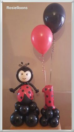 a ladybug balloon sitting on top of a table next to a number one