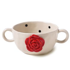 a white bowl with a red rose painted on the side and black dots around it