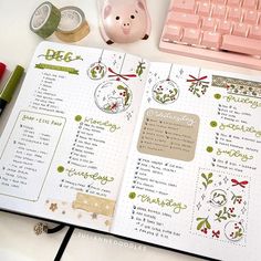 an open planner with christmas decorations on it next to a pink keyboard and mouse, along with other items