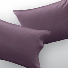 two purple pillows sitting next to each other