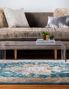 a living room with a couch, coffee table and rug