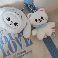 two white teddy bears are on a blue and white keychain that says, keep your love i'm my bag everyone