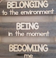 a wooden sign that says belonging to the environment being in the moment becoming me