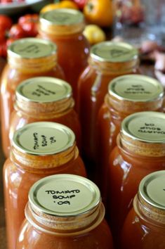 several jars of tomato sauce are lined up on a table with tomatoes in the background