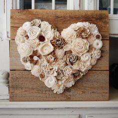 a heart made out of flowers sitting on top of a wooden box