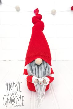 a red and white knitted gnome with grey hair