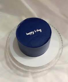 a blue birthday cake sitting on top of a white plate with the words happy b - day written on it