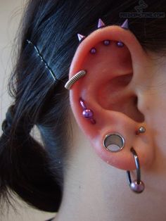 a woman with pink and silver piercings on her ear