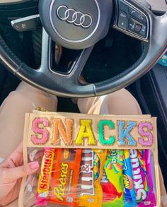 someone holding up some snacks in their car