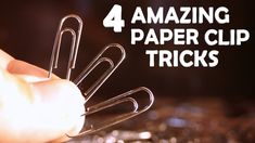 a hand holding some paper clips with the words amazing paper clip tricks on it's side