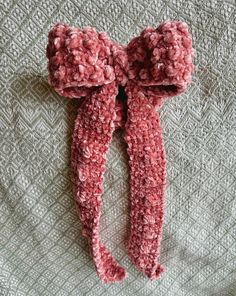 a pair of pink knitted leg warmers laying on top of a bed