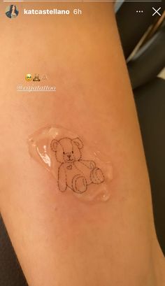 a small teddy bear drawn on the side of a woman's leg with clear plastic