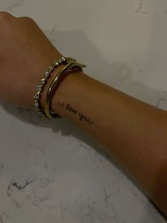 a woman's arm with a tattoo on it that says i love you in cursive writing